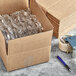 A Lavex corrugated cardboard shipping box with plastic wrap inside next to a pen.