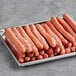 A metal tray of frozen Nathan's Famous beef franks.