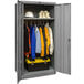 A gray metal Hallowell wardrobe cabinet with solid doors filled with clothes and tools.