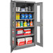 A Hallowell gray storage cabinet with Safety-View doors open to reveal shelves with various cleaning products.