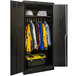 A black metal cabinet with solid doors and clothes on hangers.