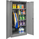 A gray steel Hallowell combination cabinet with shelves full of laundry detergents.