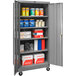 A gray Hallowell mobile storage cabinet with shelves and solid doors full of products.