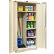 A Hallowell tan combination cabinet with shelves holding cleaning supplies and a broom.