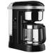 A black KitchenAid 12-cup coffee maker with a glass carafe.