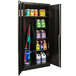 A black metal Hallowell combination cabinet with cleaning supplies on a shelf.