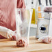 A person wearing gloves weighs meat in a Choice plastic food bag.