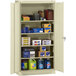 A Tennsco putty storage cabinet with solid doors filled with various items.