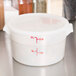A white plastic Cambro food storage container lid with red writing.