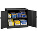 A black Tennsco jumbo storage cabinet with solid doors and shelves full of boxes.