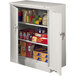 A light gray Tennsco storage cabinet with solid doors and shelves full of boxed and canned food.