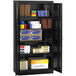 A black metal Tennsco storage cabinet with shelves and boxes.