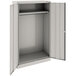 A light gray metal Tennsco wardrobe cabinet with solid doors.