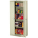 A Tennsco putty metal storage cabinet with shelves holding various items.