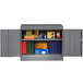 A dark gray Tennsco storage cabinet with books and boxes.