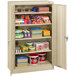 A Tennsco sand standard storage cabinet with solid doors and items on it.