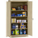 A Tennsco sand metal storage cabinet with solid doors filled with various items.