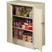 A sand Tennsco storage cabinet with solid doors full of food and other items.