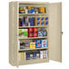 A Tennsco sand jumbo storage cabinet with solid doors filled with items.