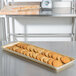 A MFG Tray Goldtex fiberglass bakery display tray with cookies on a table.