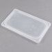 A Cambro translucent plastic food container lid on a gray surface.