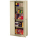 A Tennsco sand metal storage cabinet with shelves and solid doors.