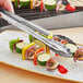 Choice stainless steel utility tongs being used to serve grilled vegetables.