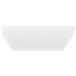 A CAC Super White porcelain sauce dish with scalloped edges.
