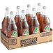 A case of 8 Jarritos Tamarind Soda glass bottles filled with brown liquid.