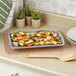A Wilton small non-stick baking sheet with roasted vegetables on a counter.
