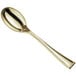 A close-up of a Visions gold plastic tasting spoon with a long handle.