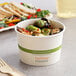 A white World Centric compostable paper food cup filled with food.
