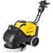 A yellow and black Tornado walk behind floor scrubber with wheels and a handle.