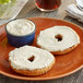 A bagel with Sweet Honey Cream Cheese Spread on a plate.