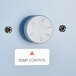 The temperature control knob with numbers on a white surface.