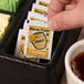 A tray of tea with Honey 12 Gram Portion Control packets on a hotel buffet counter.
