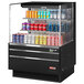 A black Turbo Air horizontal refrigerated open curtain merchandiser with drinks and cans on shelves.