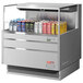 A Turbo Air stainless steel horizontal refrigerated curtain merchandiser on a counter filled with cans of soda.