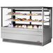 A Turbo Air stainless steel refrigerated bakery display case filled with different types of cakes on shelves.
