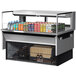 A Turbo Air stainless steel drop-in refrigerated display case with a variety of drinks and cans.