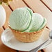 A bowl of green ice cream with a spoon.