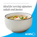 A gray matte stoneware bowl filled with soup, ideal for serving salads and pastas.