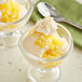 Two glasses of ice cream with Oringer pineapple topping and whipped cream.