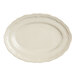 An Acopa Condesa warm gray porcelain oval platter with a scalloped edge.
