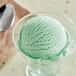 A bowl of green mint ice cream with a spoon.
