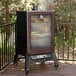 A large black and copper Pit Boss vertical pellet smoker with food inside.