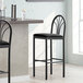 A Lancaster Table & Seating black bar stool with black fabric seat and back.