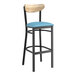A Lancaster Table & Seating Boomerang bar stool with blue vinyl seat and black frame.