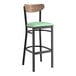A Lancaster Table & Seating bar stool with a seafoam vinyl seat and black frame.