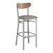 A Lancaster Table & Seating bar stool with a dark gray vinyl seat and vintage wood back.